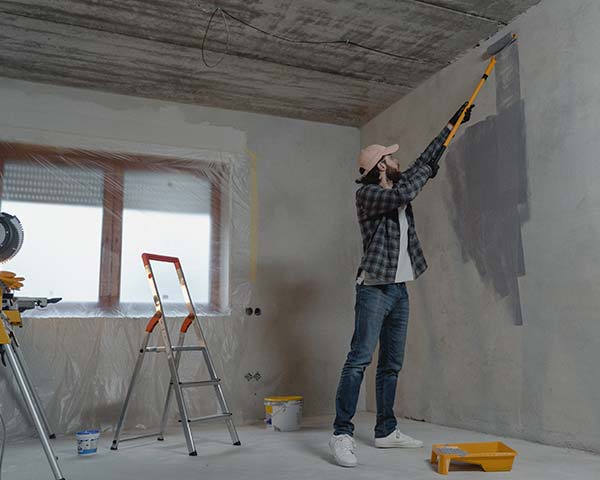 man painting an interior wall